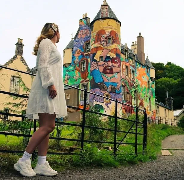 A woman looking at Kelburn castle