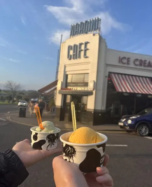Hands holding ice cream in front of Nardini Cafe 